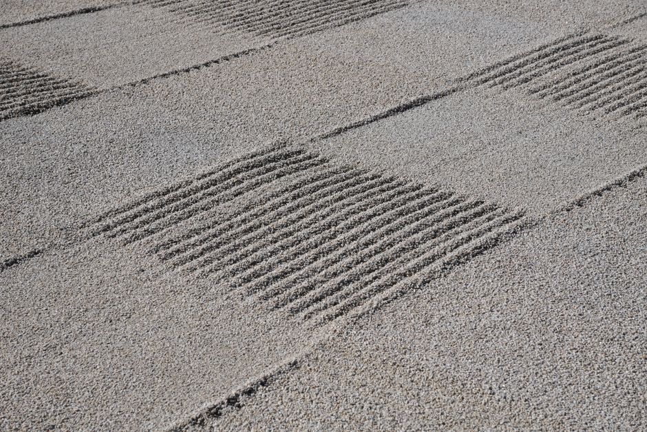 Detailed view of a Zen garden's raked gravel patterns in Kyoto, Japan, showcasing tranquility.